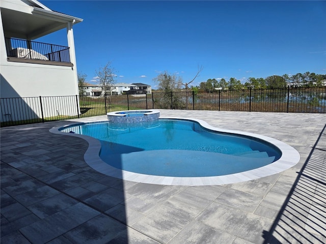 view of swimming pool with a pool with connected hot tub, a patio area, and fence