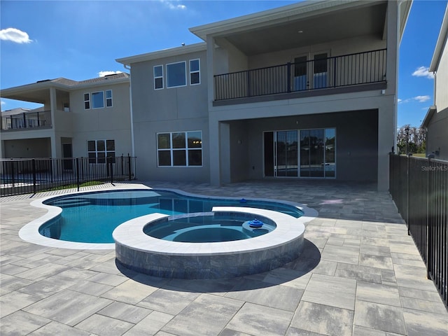 view of pool featuring a patio area, fence, and a pool with connected hot tub