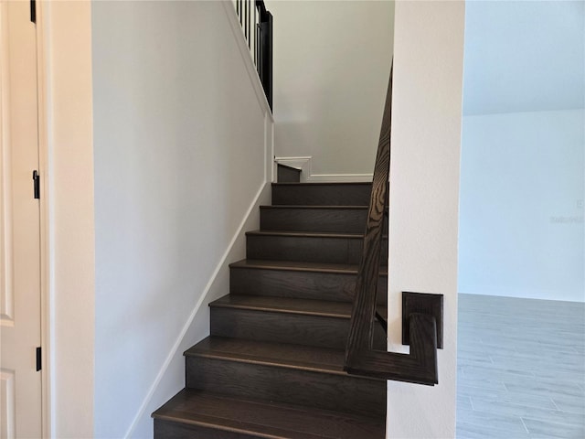 stairway featuring baseboards and wood finished floors