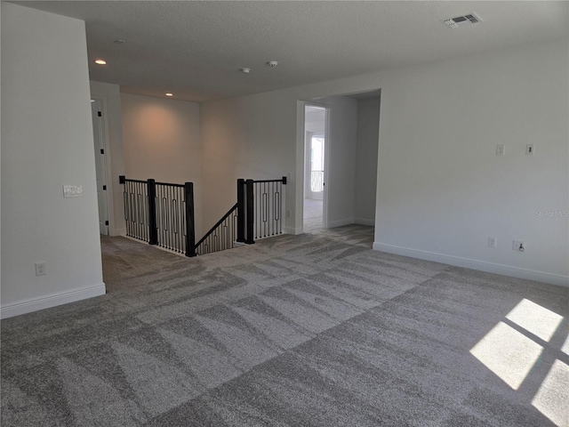 carpeted empty room with recessed lighting, visible vents, and baseboards