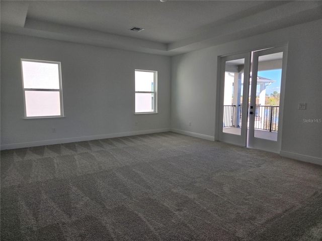 empty room with a healthy amount of sunlight, visible vents, baseboards, and carpet flooring