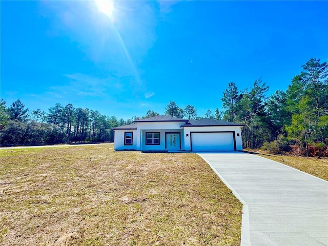 view of front facade featuring a garage, a front lawn, concrete driveway, and stucco siding