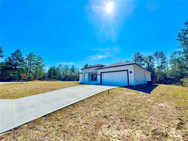 view of front of property featuring a garage, a front yard, driveway, and stucco siding