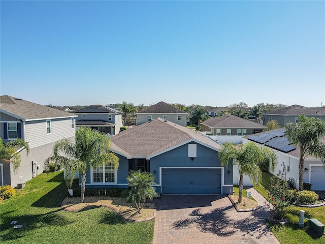 single story home featuring a garage, decorative driveway, a residential view, and stucco siding