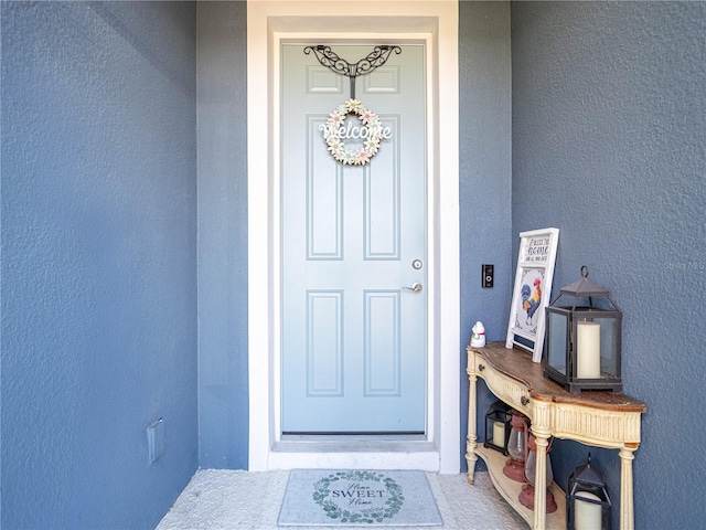 doorway to property featuring stucco siding