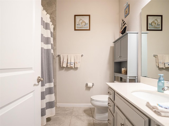 bathroom featuring baseboards, vanity, toilet, and tile patterned floors