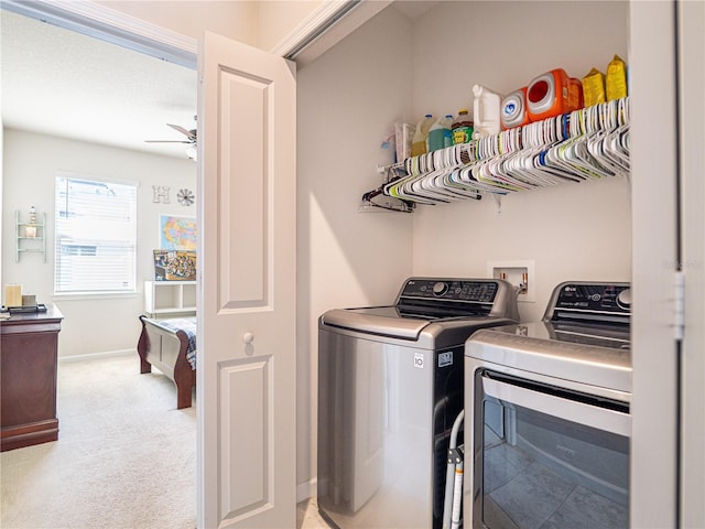 laundry area with light colored carpet, a ceiling fan, washing machine and dryer, laundry area, and baseboards