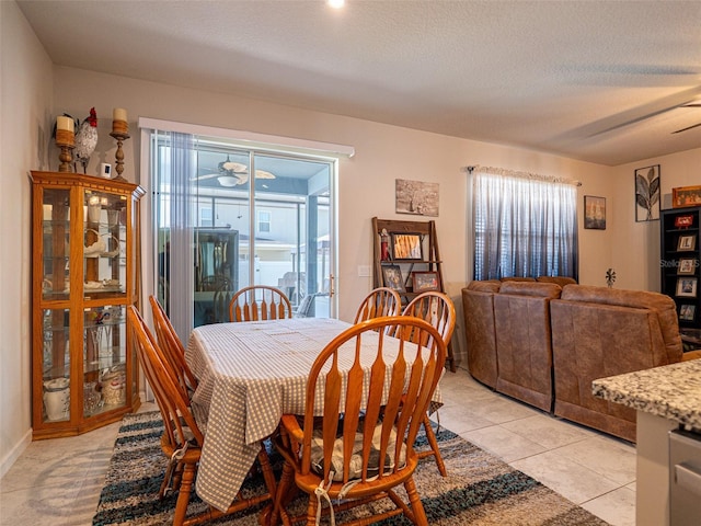 dining space with a ceiling fan and a textured ceiling