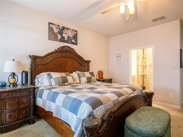 bedroom featuring ceiling fan, ensuite bathroom, light carpet, visible vents, and baseboards