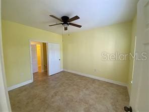 interior space with ceiling fan and baseboards