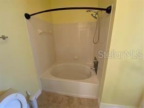 bathroom with toilet and shower / bathing tub combination