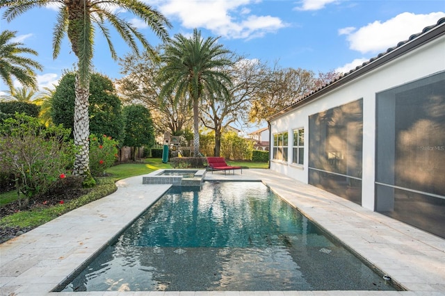 view of swimming pool featuring a patio area, a fenced backyard, and a pool with connected hot tub