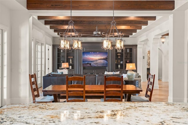 dining area with baseboards, a chandelier, arched walkways, and beamed ceiling