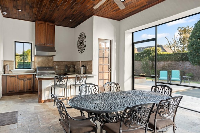 dining space with stone tile flooring and wood ceiling