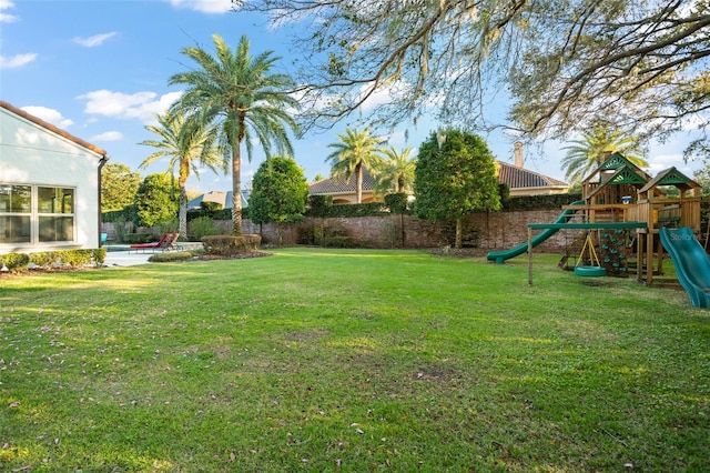 view of yard featuring a patio, a playground, and fence