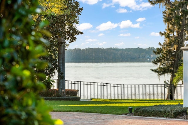 view of water feature featuring a forest view and fence