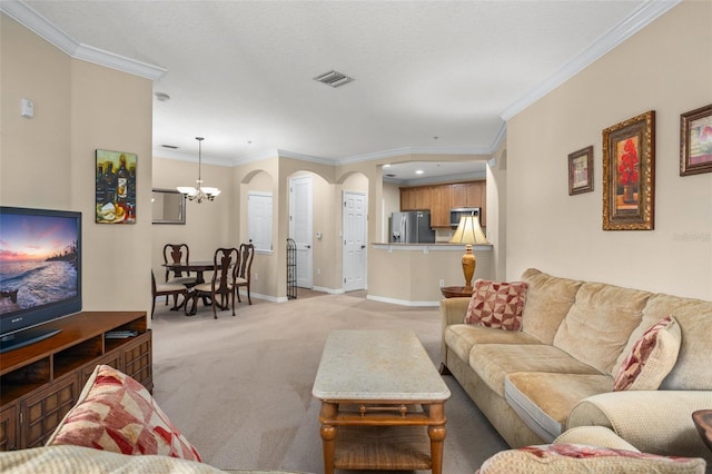 living room with baseboards, visible vents, light colored carpet, crown molding, and a chandelier