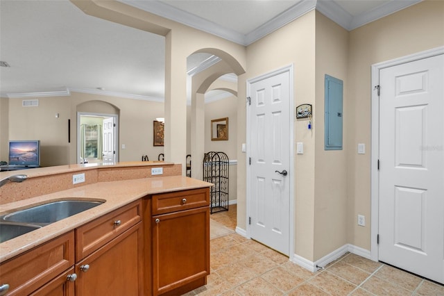 kitchen featuring light tile patterned floors, electric panel, visible vents, brown cabinets, and a sink