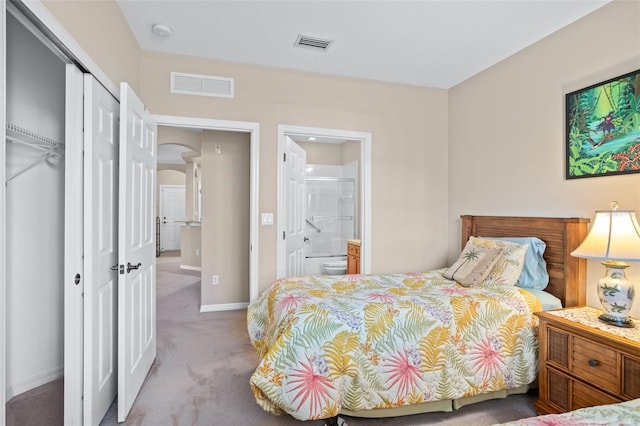 carpeted bedroom featuring arched walkways, a closet, visible vents, and baseboards