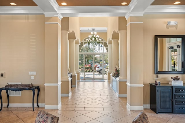 hall with crown molding, an inviting chandelier, and ornate columns