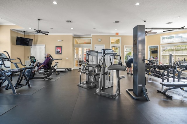 workout area featuring a textured ceiling, ceiling fan, and crown molding