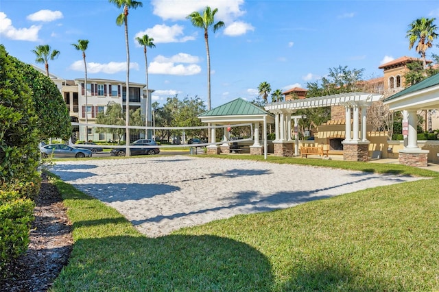 view of community with a pergola, a lawn, and volleyball court