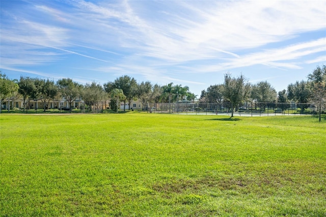 surrounding community with a yard and fence