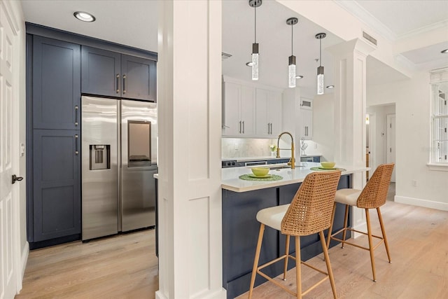 kitchen featuring a breakfast bar area, light wood-style flooring, visible vents, light countertops, and stainless steel refrigerator with ice dispenser