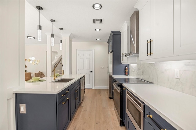 kitchen with stainless steel appliances, tasteful backsplash, light countertops, visible vents, and a sink