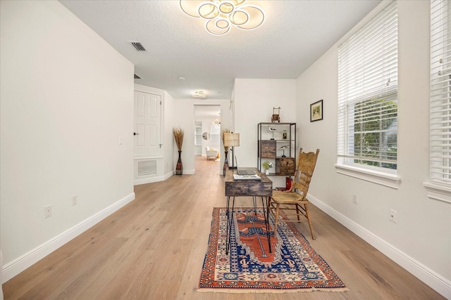 interior space featuring baseboards, visible vents, and light wood-style floors