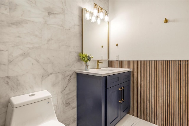 bathroom featuring toilet, vanity, and wainscoting