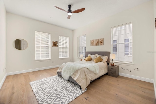 bedroom with light wood-style flooring, baseboards, and a ceiling fan