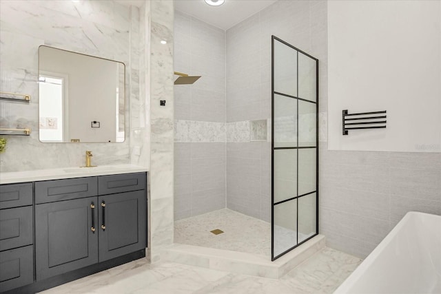 full bath with marble finish floor, tiled shower, a freestanding bath, and tile walls