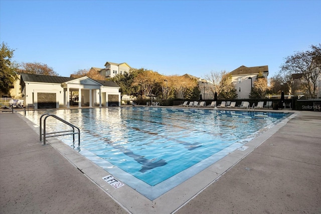 pool featuring an outbuilding, a patio, and a storage structure