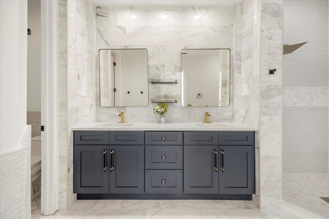 bathroom with a walk in shower, double vanity, a sink, and tile walls