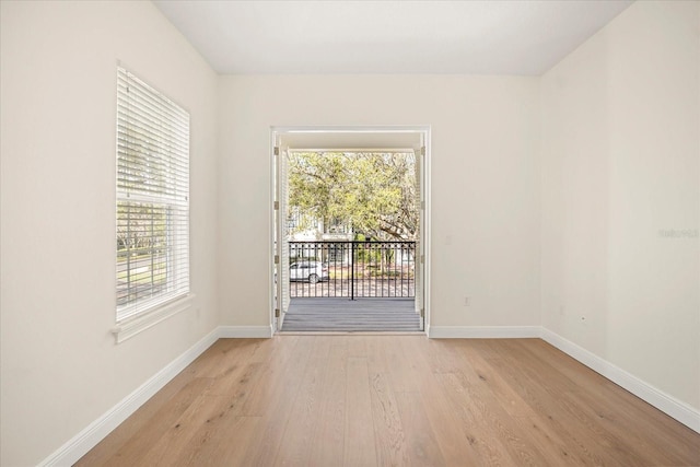 spare room featuring light wood-style floors and baseboards