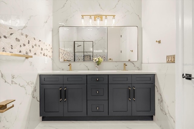 bathroom with double vanity, marble finish floor, tile walls, and a sink