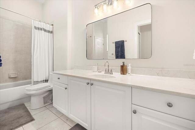 bathroom featuring toilet, tile patterned floors, shower / bath combo with shower curtain, and vanity