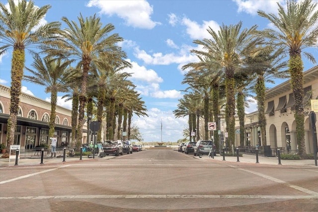 view of road with sidewalks, street lighting, traffic signs, and curbs