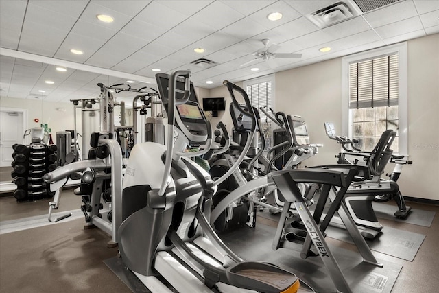 workout area with ceiling fan, a paneled ceiling, and visible vents