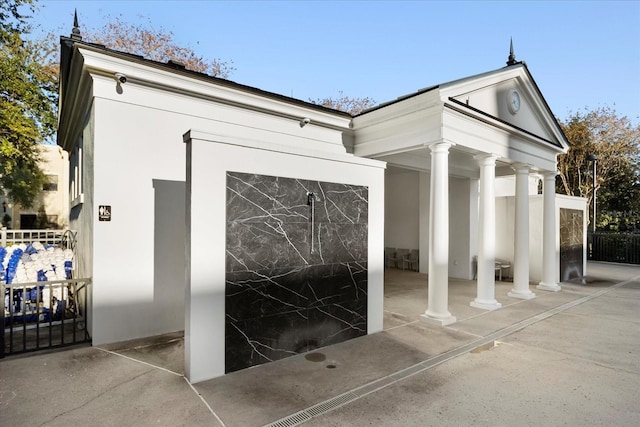 view of exterior entry featuring fence and stucco siding