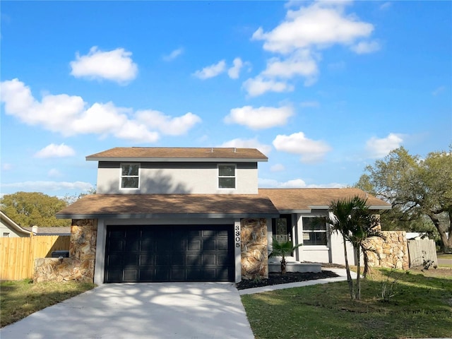 traditional home with stone siding, fence, concrete driveway, and stucco siding