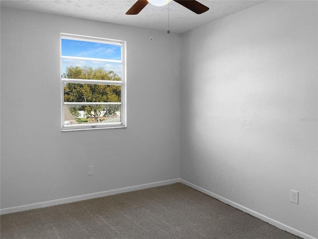 empty room with carpet floors, ceiling fan, a textured ceiling, and baseboards