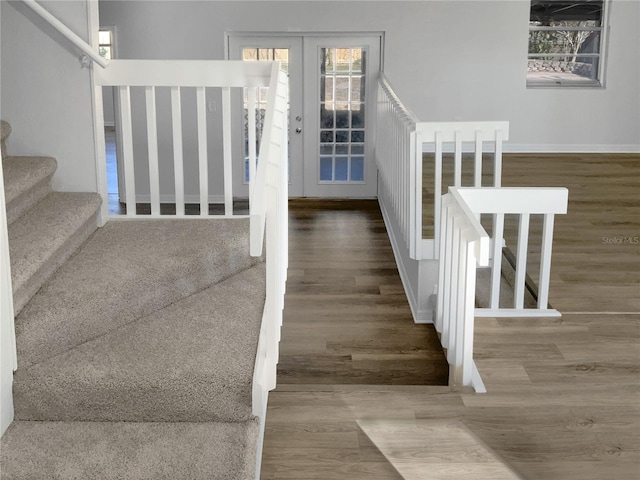 stairs with french doors and wood finished floors