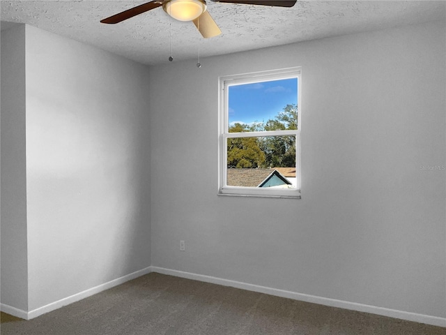 carpeted empty room with ceiling fan, a textured ceiling, and baseboards