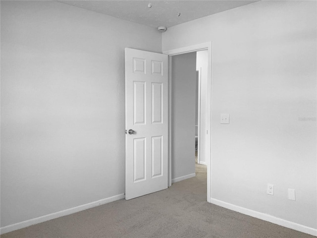 carpeted empty room with baseboards