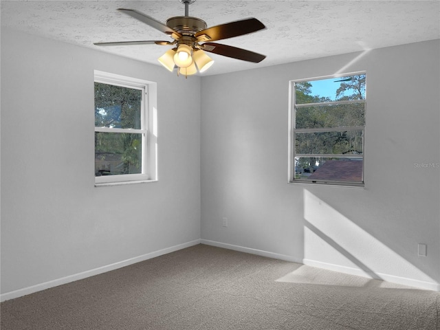 unfurnished room featuring a ceiling fan, a textured ceiling, baseboards, and carpet flooring