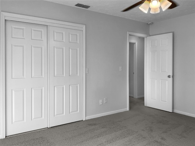 unfurnished bedroom featuring a textured ceiling, visible vents, baseboards, a closet, and carpet