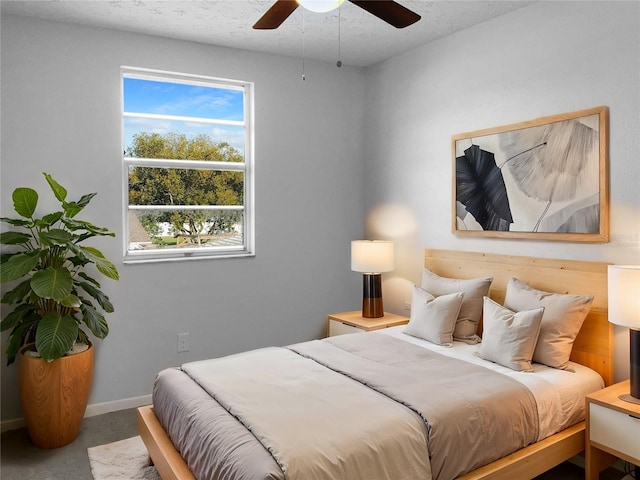 bedroom featuring a textured ceiling, a ceiling fan, and baseboards