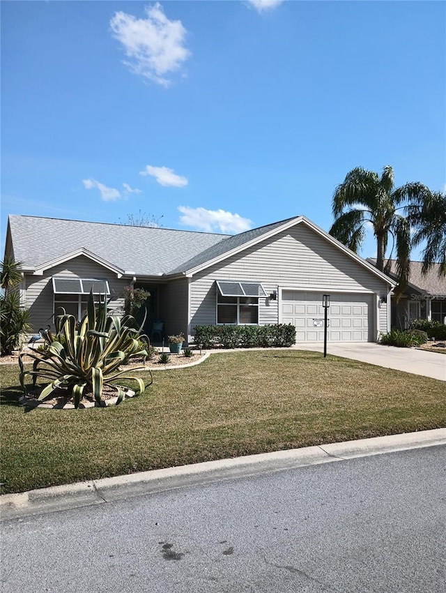 ranch-style home with a garage, concrete driveway, and a front yard